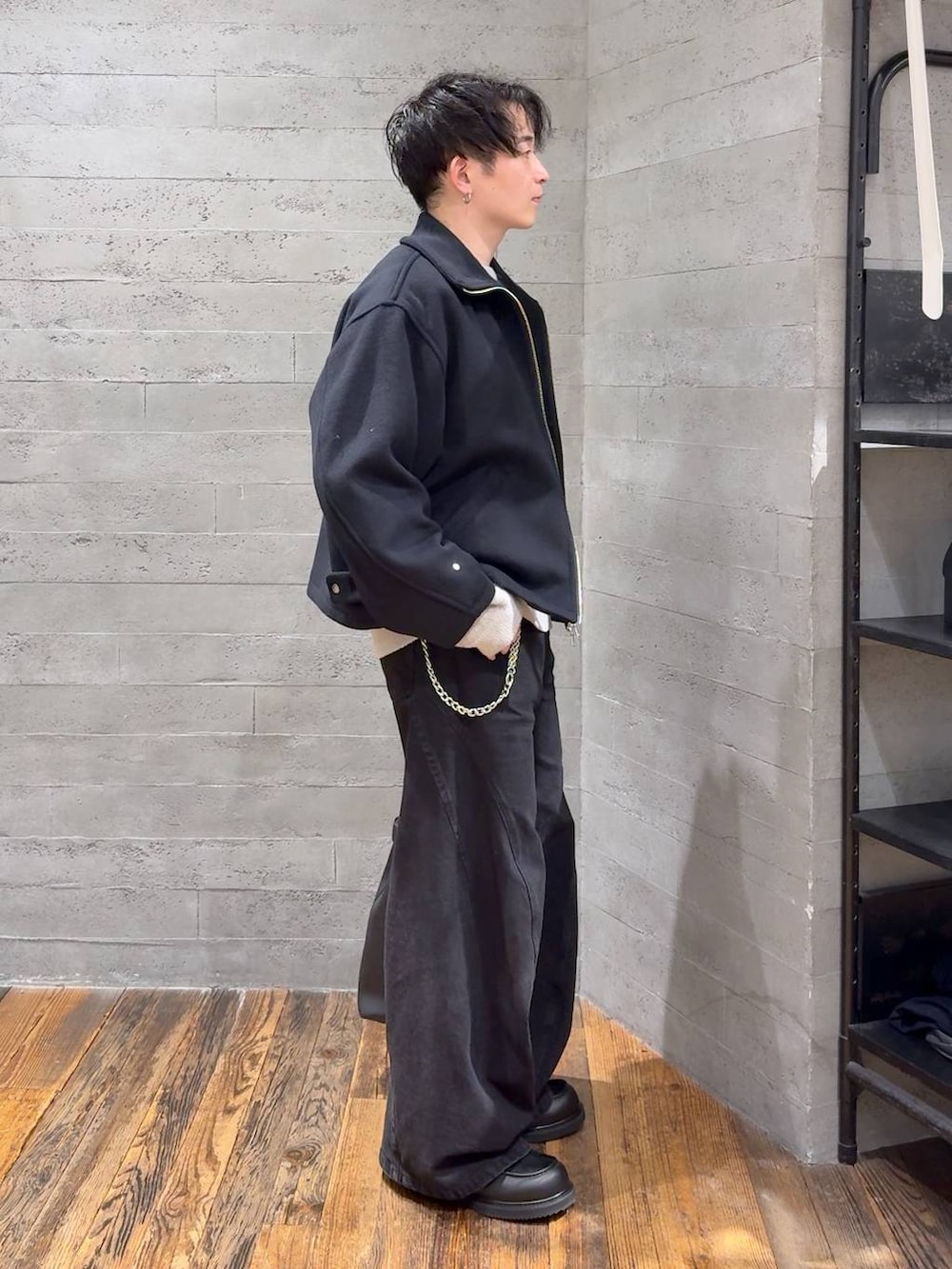 ブラック系のデニムパンツ、ブラック系のブルゾン、ブラック系のトートバッグを着用したメンズの秋コーディネートの2枚目の写真