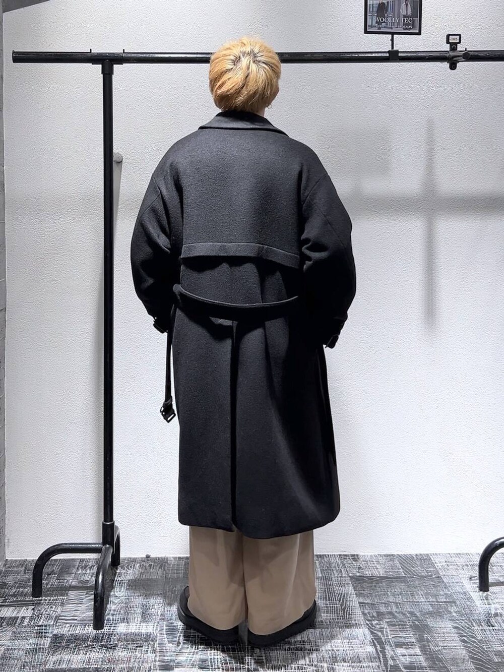 ブラック系のステンカラーコート、ブラック系のドレスシューズ、グレー系のスウェットを着用したメンズの冬コーディネートの4枚目の写真