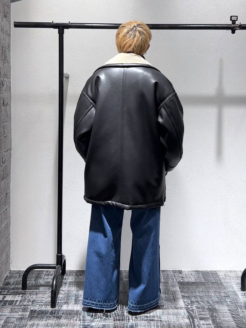 ブラック系のニット/セーター、ブラック系のショルダーバッグ、ブラック系のドレスシューズを着用したメンズの冬コーディネートの4枚目の写真