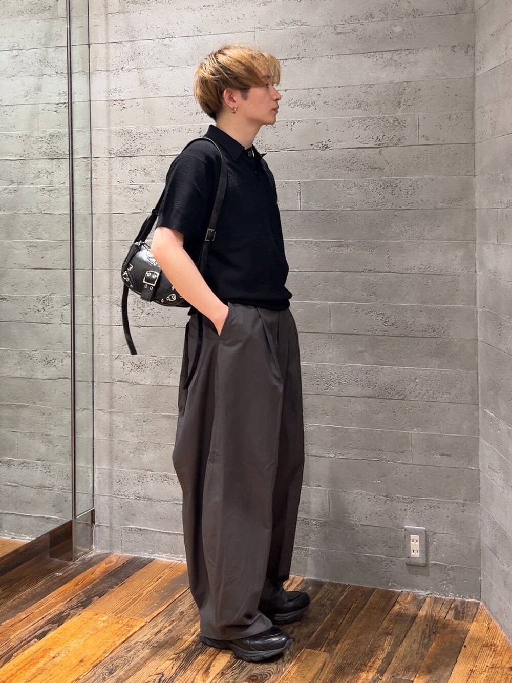 ブラック系のショルダーバッグ、ブラック系のローファー、グレー系のチノパンツを着用したメンズの夏コーディネートの4枚目の写真