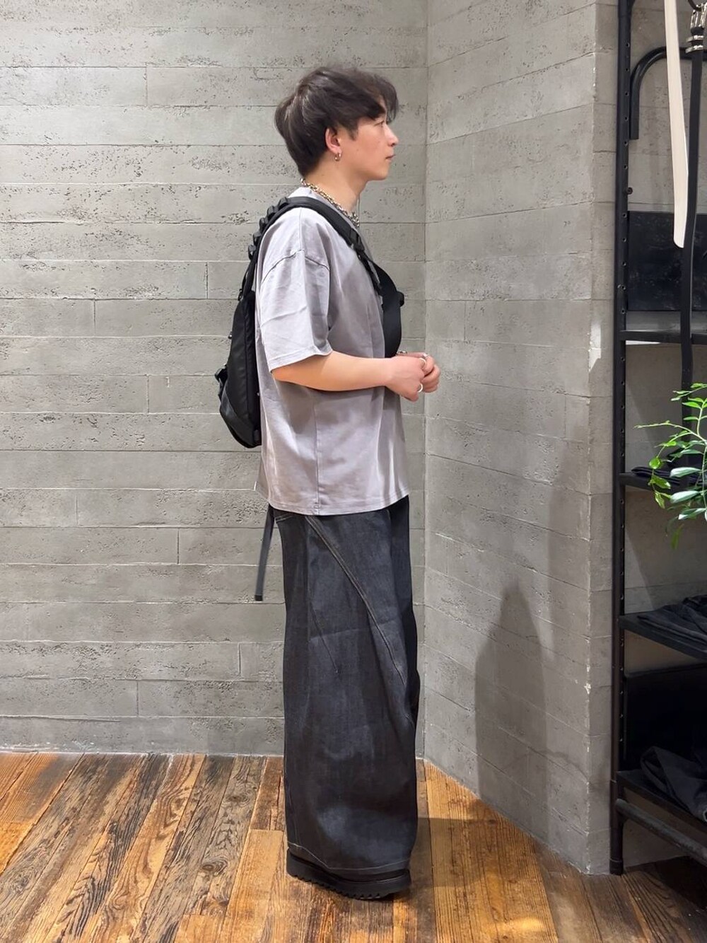 ブルー系のデニムパンツ、ブラック系のショルダーバッグ、グレー系のTシャツ/カットソーを着用したメンズの春コーディネートの2枚目の写真