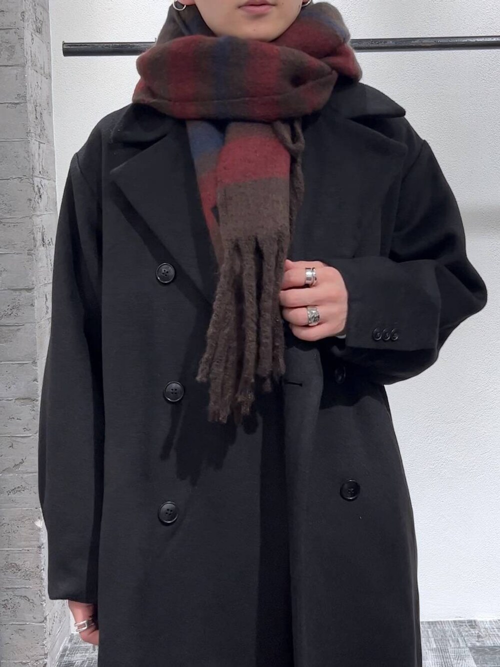 ブラック系のステンカラーコート、ブラック系のローファー、ブラック系のデニムパンツを着用したメンズの秋コーディネートの5枚目の写真