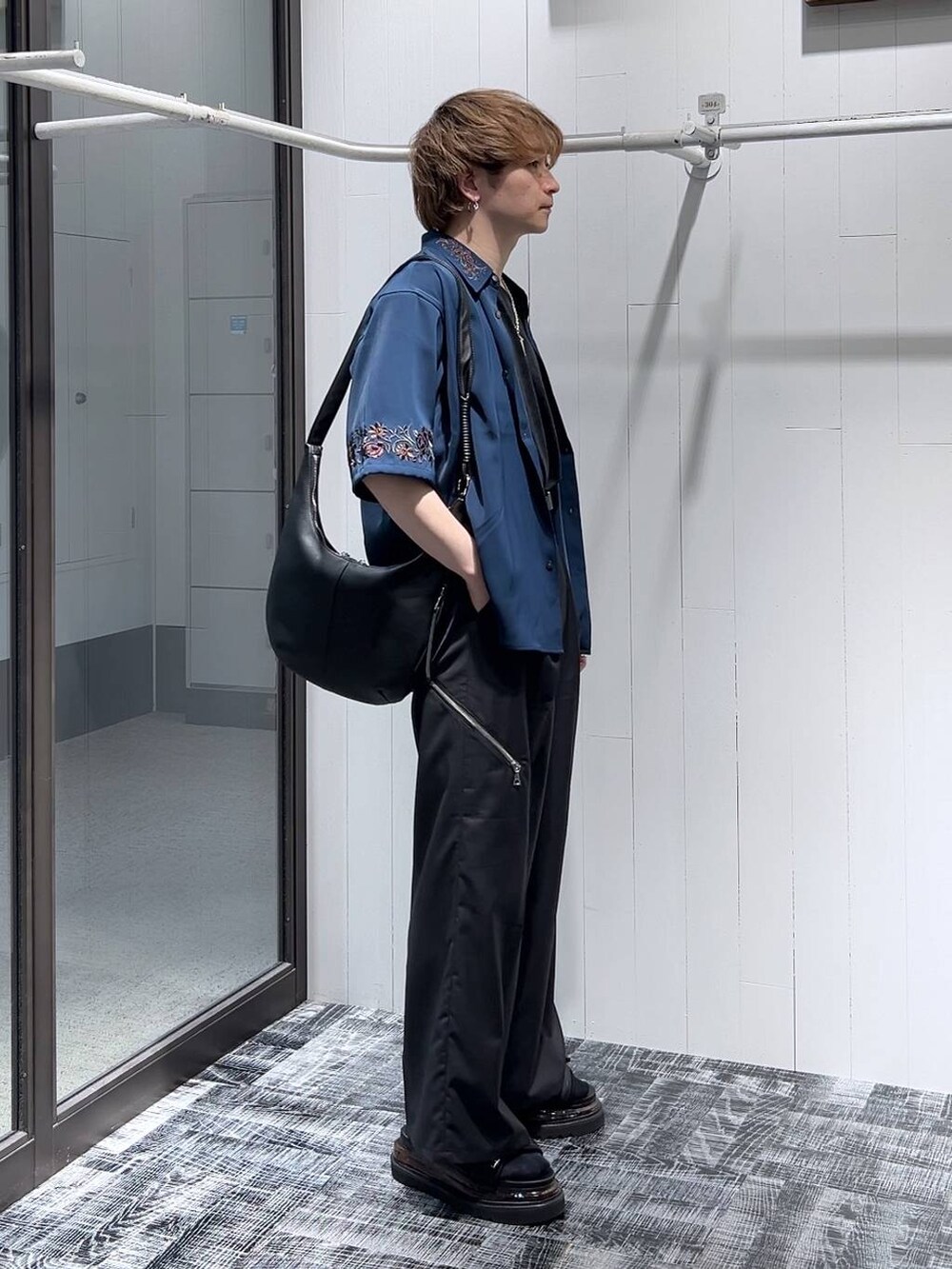 ブラック系のスラックス、ブラック系のサンダル、グレー系のTシャツ/カットソーを着用したメンズの春コーディネートの3枚目の写真