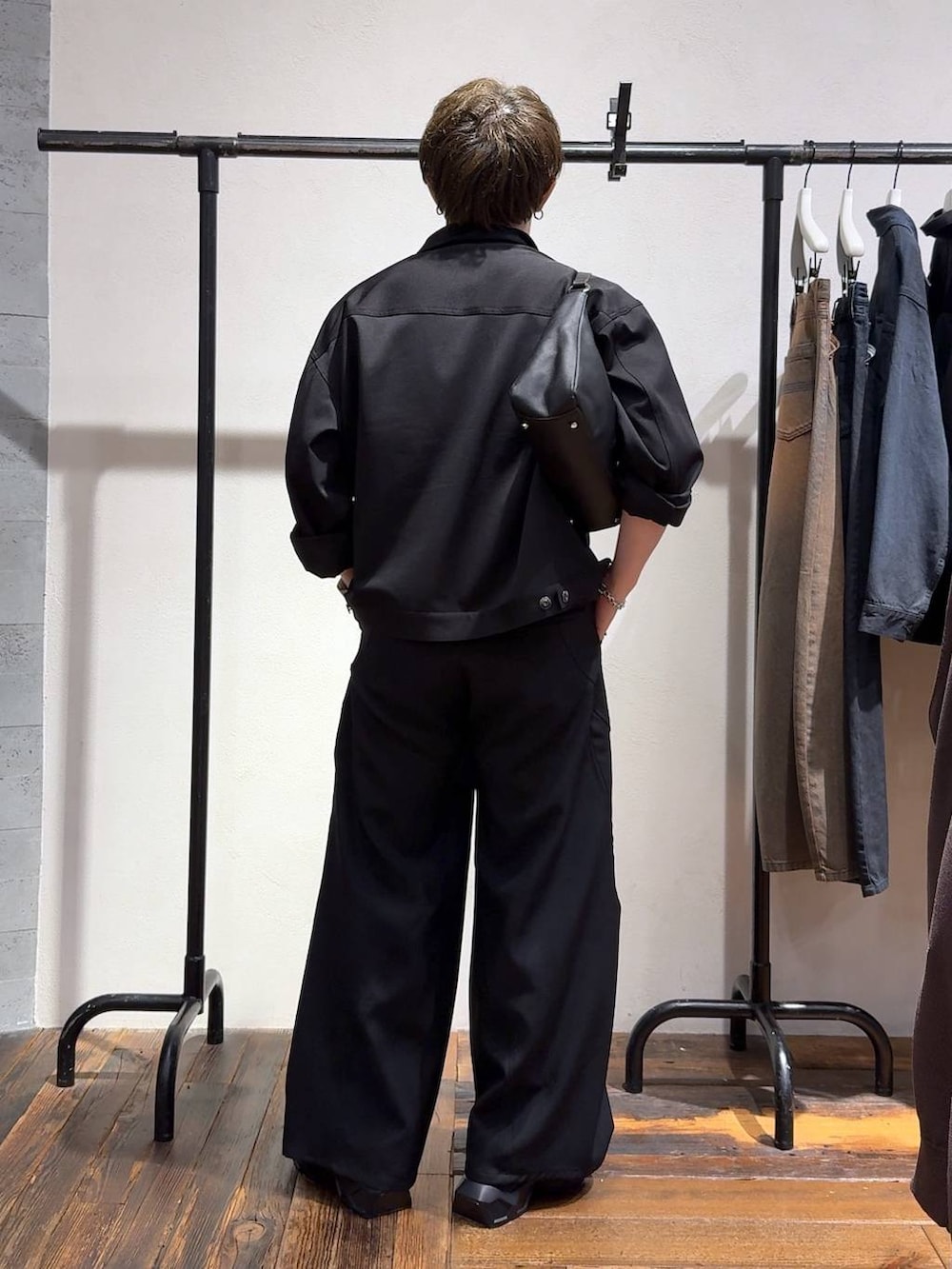ブラック系のスラックス、ブラック系のローファー、ブラック系のTシャツ/カットソーを着用したメンズの夏コーディネートの3枚目の写真