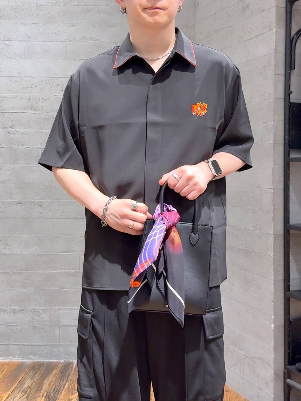 ブラック系のカーゴパンツ、レッド系のシャツ/ブラウス、ブラック系のサンダルを着用したメンズの夏コーディネートの5枚目の写真