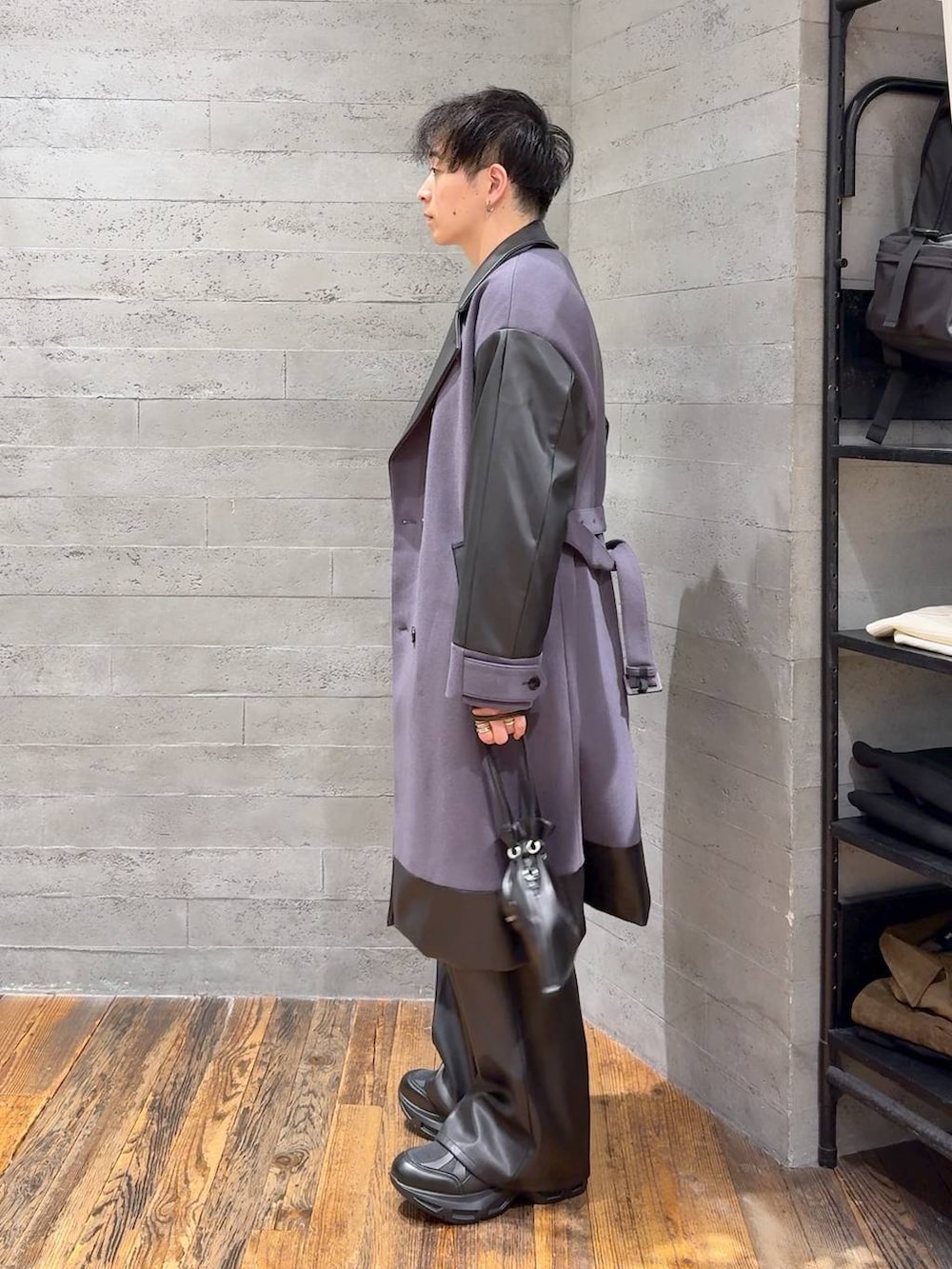 パープル系のトレンチコート、グレー系のニット/セーター、ブラック系のスラックスを着用したメンズの秋コーディネートの4枚目の写真
