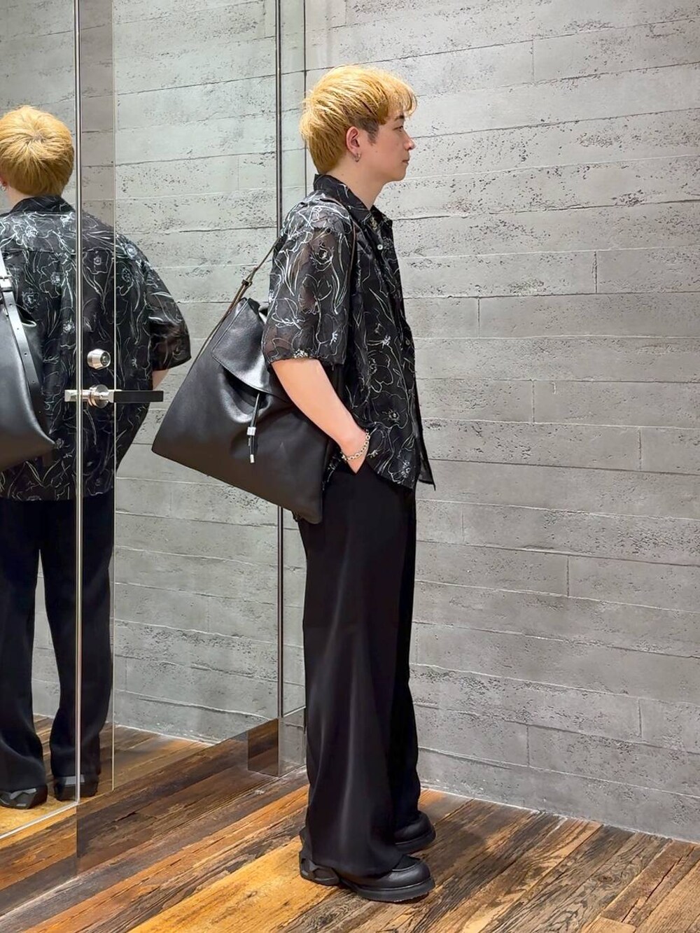 ブラック系のスラックス、ブラック系のローファー、ブラック系のTシャツ/カットソーを着用したメンズの春コーディネートの2枚目の写真