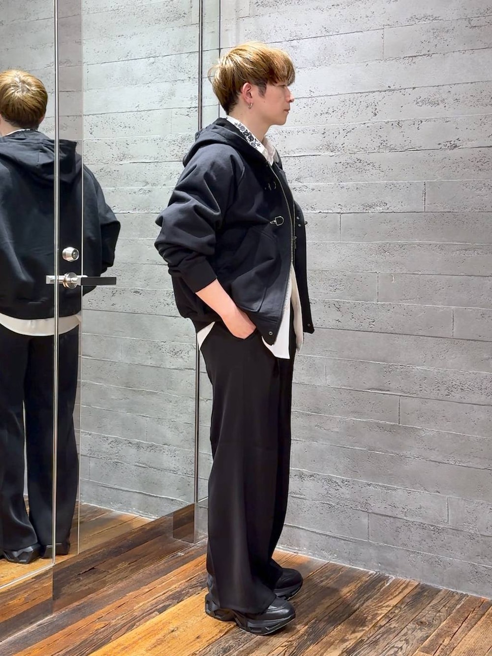 ブラック系のスラックス、ブラック系のスニーカー、ホワイト系のシャツ/ブラウスを着用したメンズの春コーディネートの2枚目の写真