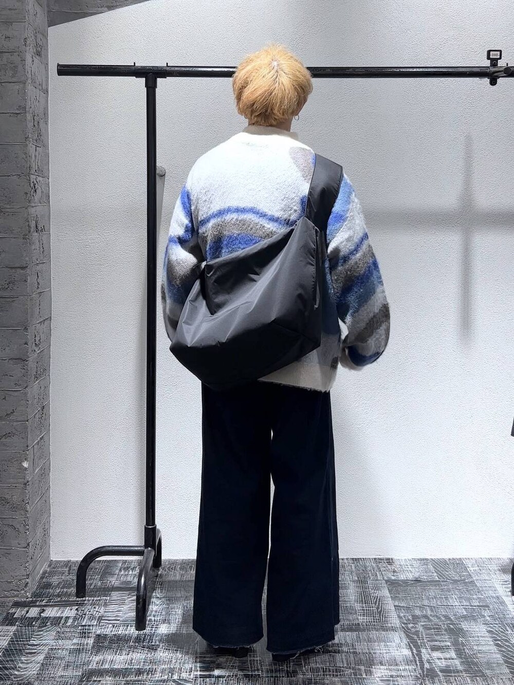 ブラック系のドレスシューズ、ブルー系のデニムパンツ、ホワイト系のニット/セーターを着用したメンズの秋コーディネートの4枚目の写真