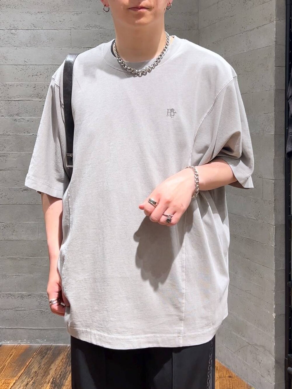 グレー系のTシャツ/カットソー、ブラック系のドレスシューズ、ブラック系のショルダーバッグを着用したメンズの夏コーディネートの5枚目の写真