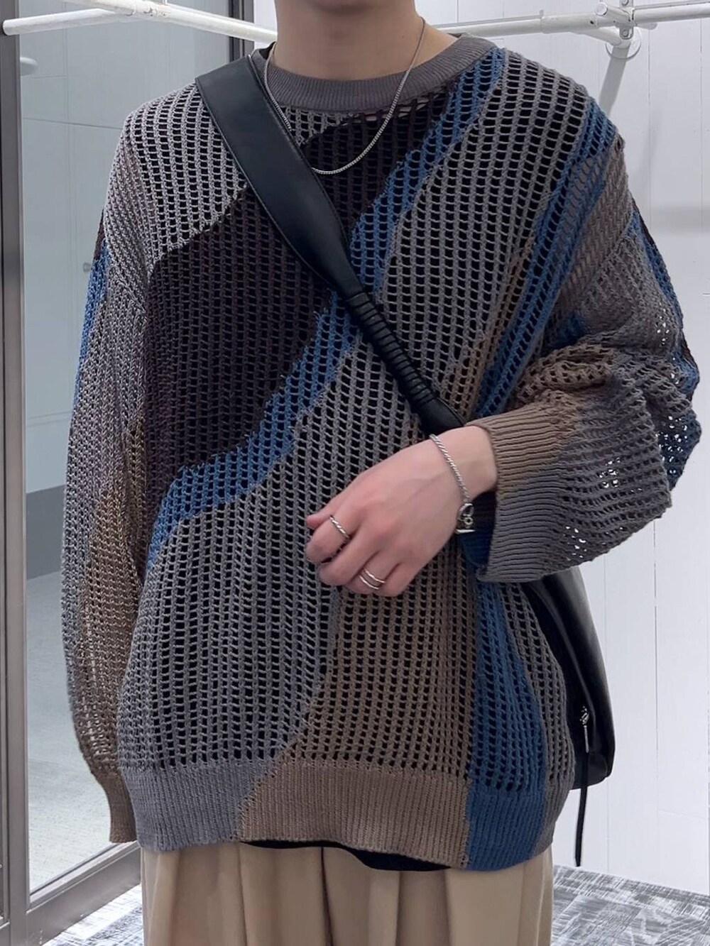 グレー系のニット/セーター、ブラック系のTシャツ/カットソー、ブラック系のドレスシューズを着用したメンズの春コーディネートの4枚目の写真