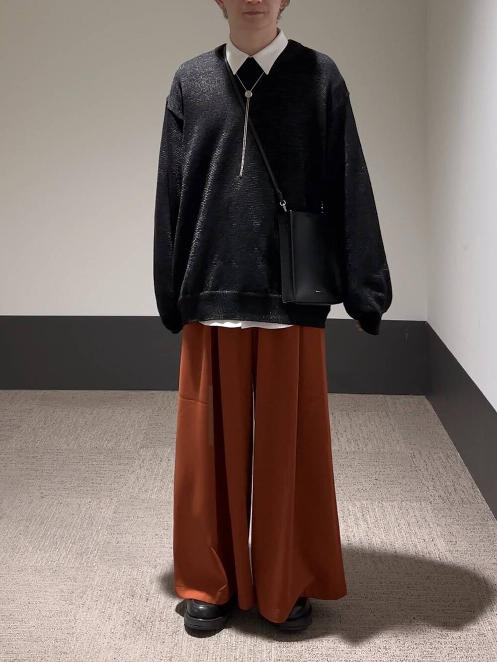 ホワイト系のシャツ/ブラウス、ブラック系のニット/セーター、ブラック系のショルダーバッグを着用したメンズの春コーディネートの2枚目の写真