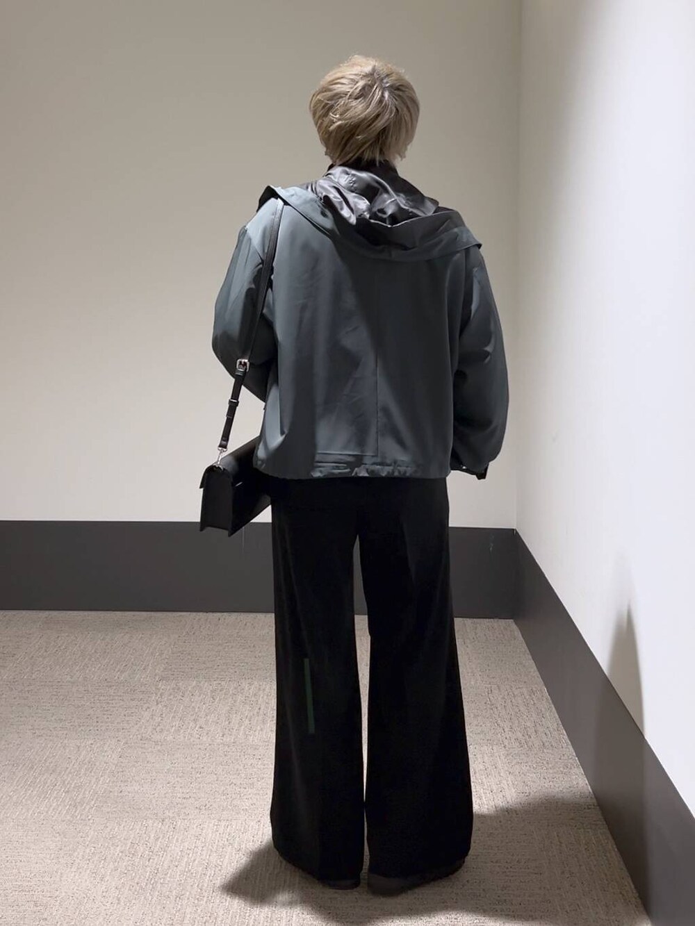 ブラック系のスラックス、ブラック系のショルダーバッグ、ブラック系のドレスシューズを着用したメンズの冬コーディネートの3枚目の写真