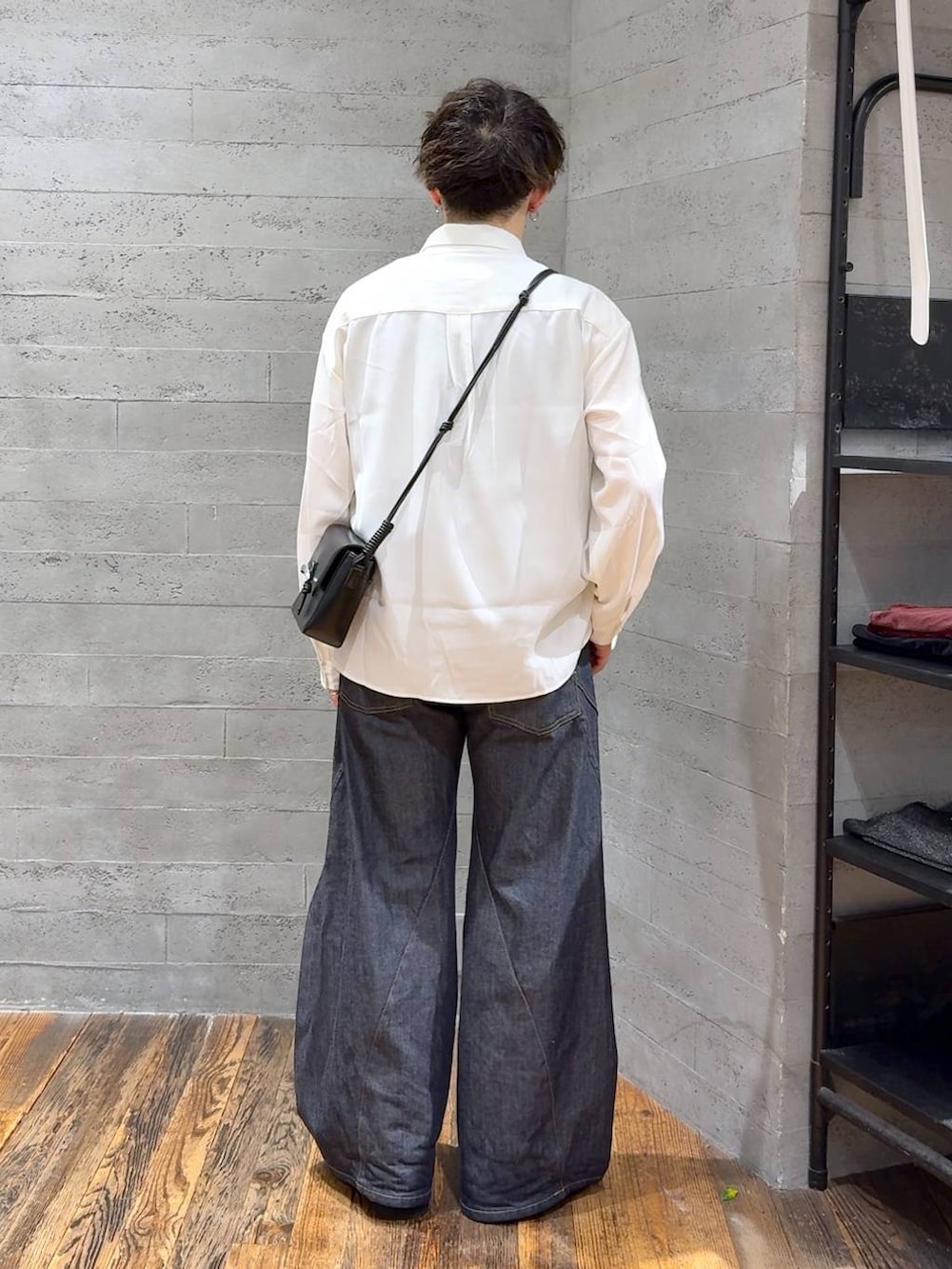 ブルー系のデニムパンツ、ブラック系のローファー、ブラック系のショルダーバッグを着用したメンズの秋コーディネートの3枚目の写真