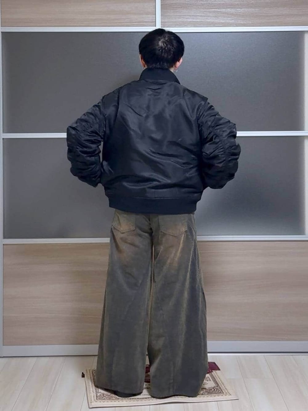 ブルー系のTシャツ/カットソー、グリーン系のデニムパンツ、シルバー系のピアス（片耳用）を着用したメンズの秋コーディネートの3枚目の写真