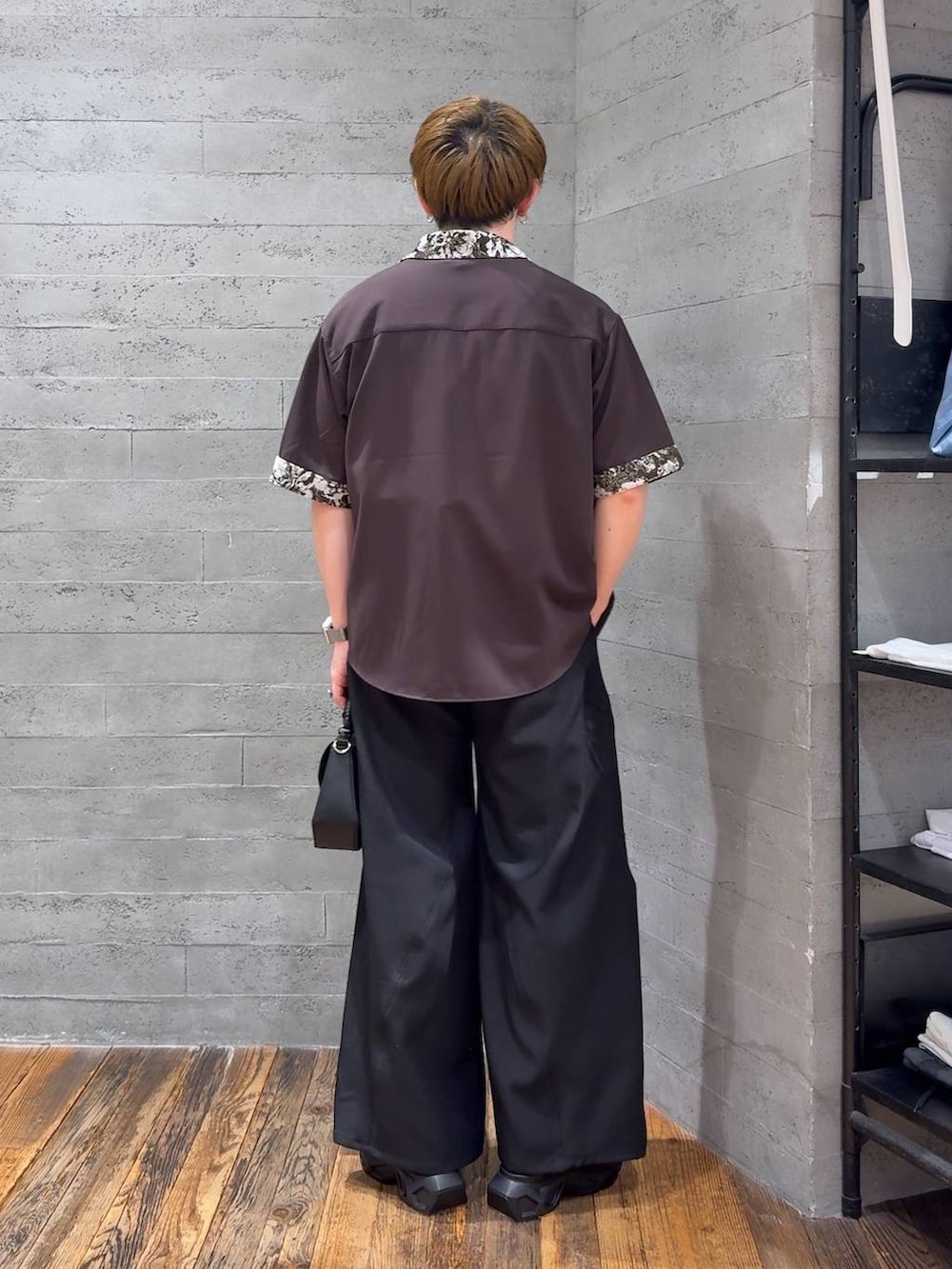 ブラック系のサンダル、ホワイト系のTシャツ/カットソー、ブラック系のスラックスを着用したメンズの春コーディネートの3枚目の写真