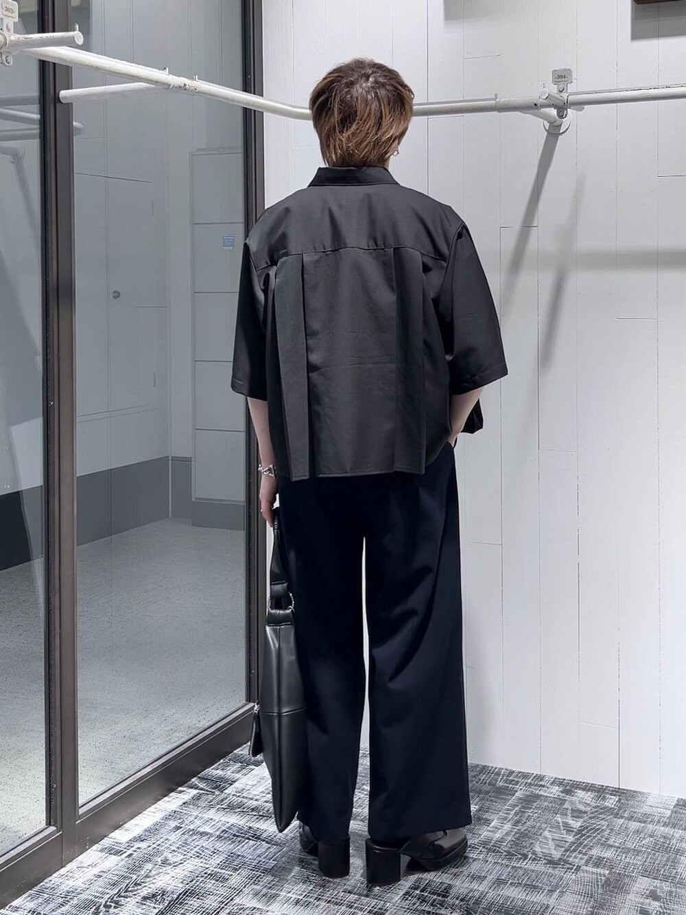 ブラック系のドレスシューズ、ブラック系のトートバッグ、ブラック系のTシャツ/カットソーを着用したメンズの春コーディネートの4枚目の写真