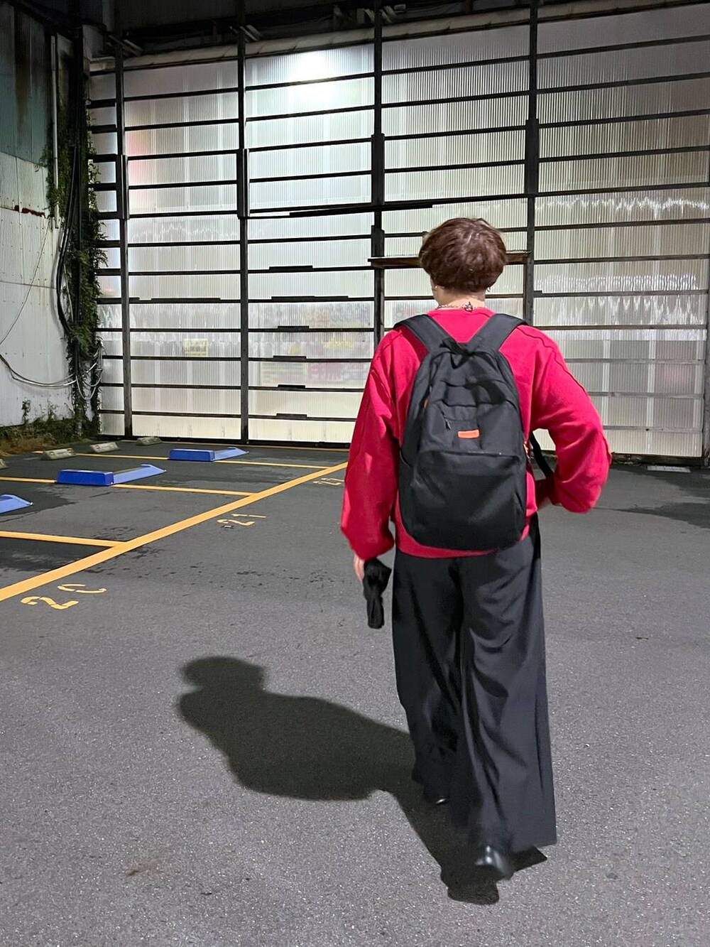 ブラック系のその他パンツ、レッド系のスウェット、シルバー系のピアス（片耳用）を着用したメンズの秋コーディネートの2枚目の写真