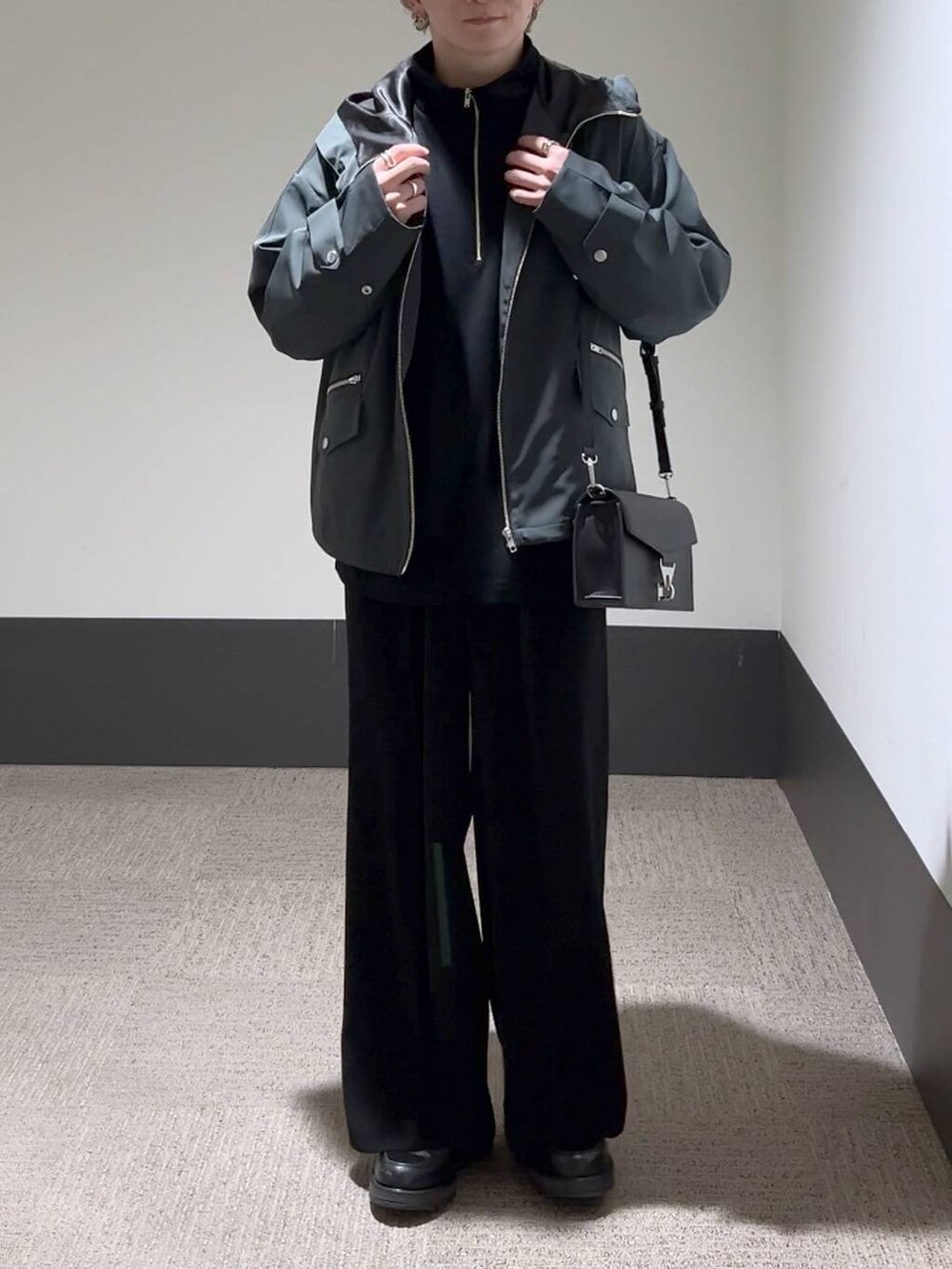 ブラック系のスラックス、ブラック系のショルダーバッグ、ブラック系のドレスシューズを着用したメンズの冬コーディネートの2枚目の写真