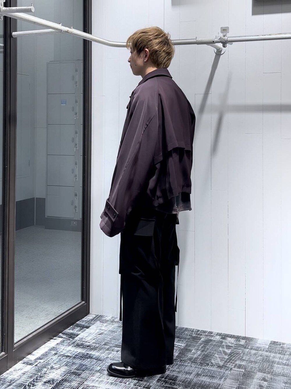 レッド系のブルゾン、ブラック系のカーゴパンツ、ブラック系のドレスシューズを着用したメンズの秋コーディネートの4枚目の写真