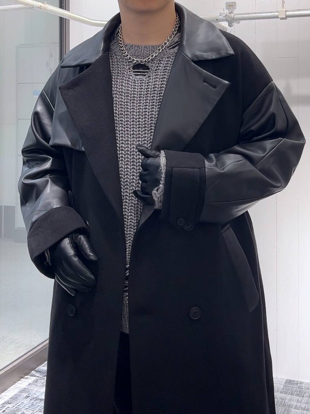 ブラック系のトレンチコート、ブラック系のその他シューズ、グレー系のニット/セーターを着用したメンズの秋コーディネートの5枚目の写真