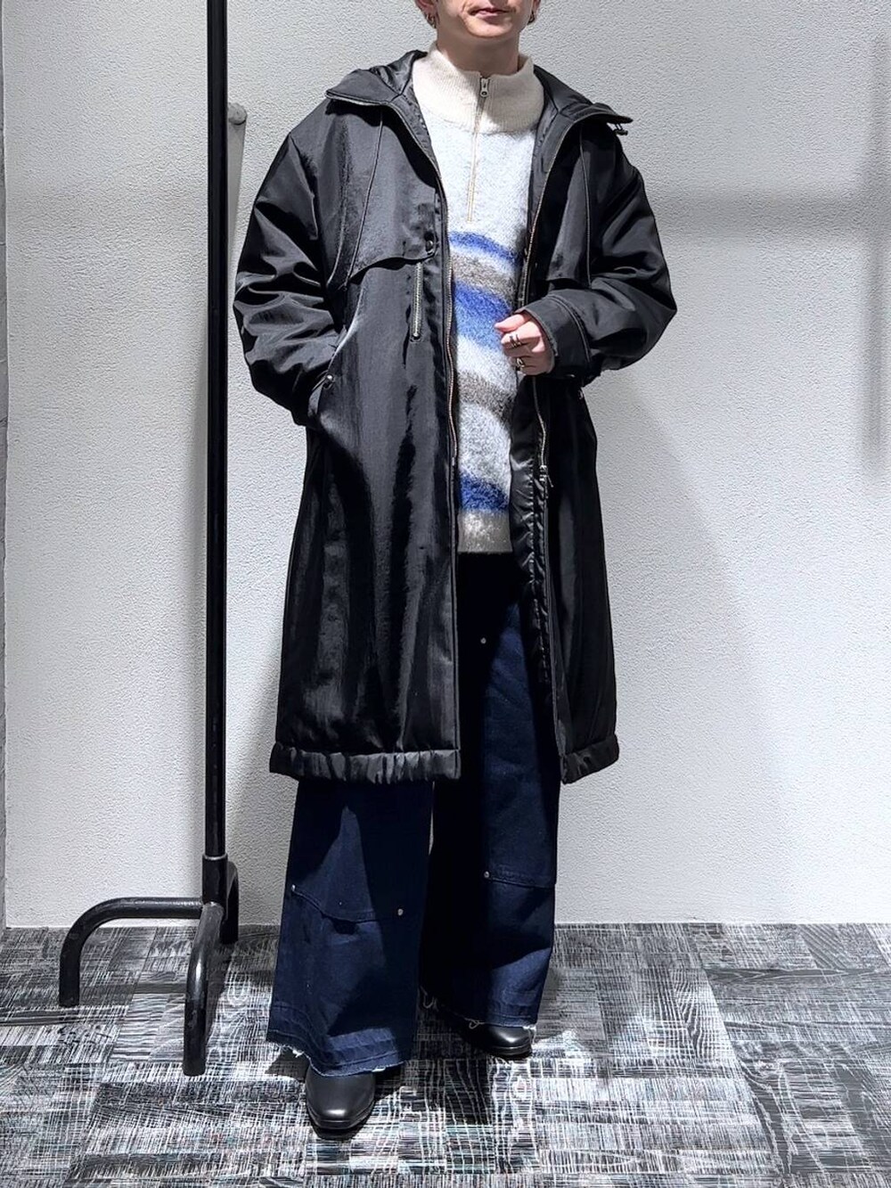 ブラック系のドレスシューズ、ブルー系のデニムパンツ、ホワイト系のニット/セーターを着用したメンズの秋コーディネートの2枚目の写真
