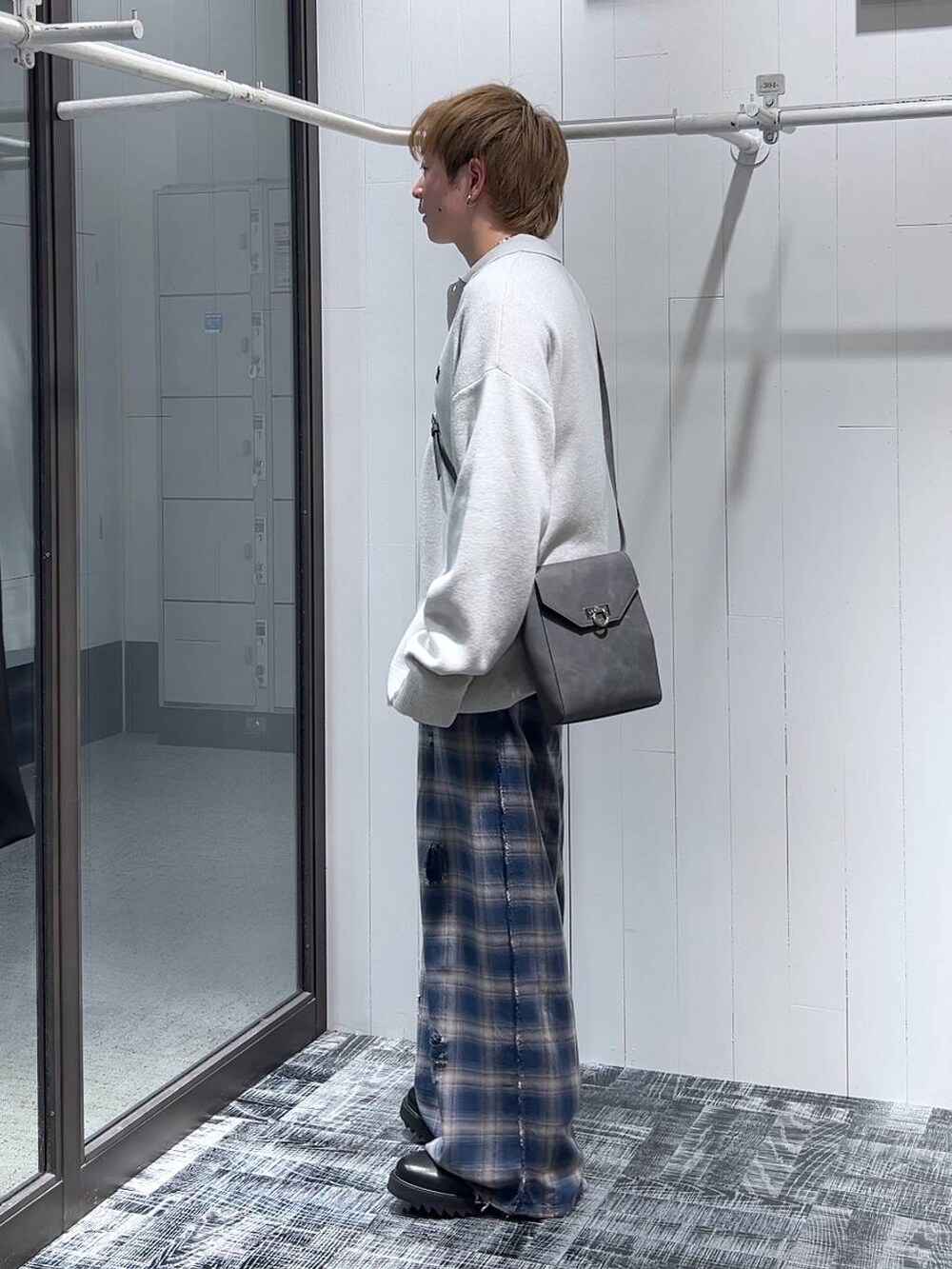 ブルー系のその他パンツ、ブラック系のドレスシューズ、グレー系のショルダーバッグを着用したメンズの冬コーディネートの4枚目の写真