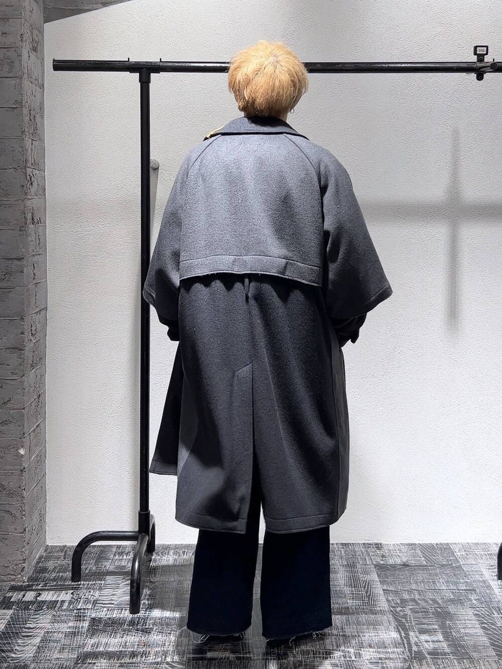 ブラック系のドレスシューズ、ブルー系のデニムパンツ、グレー系のトレンチコートを着用したメンズの秋コーディネートの4枚目の写真