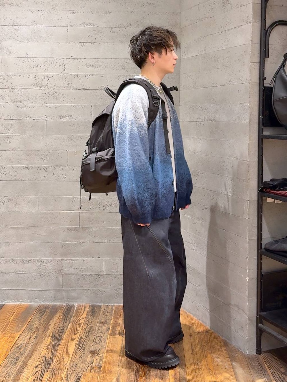ブルー系のデニムパンツ、ブルー系のカーディガン/ボレロ、ブラック系のバックパック/リュックを着用したメンズの秋コーディネートの2枚目の写真