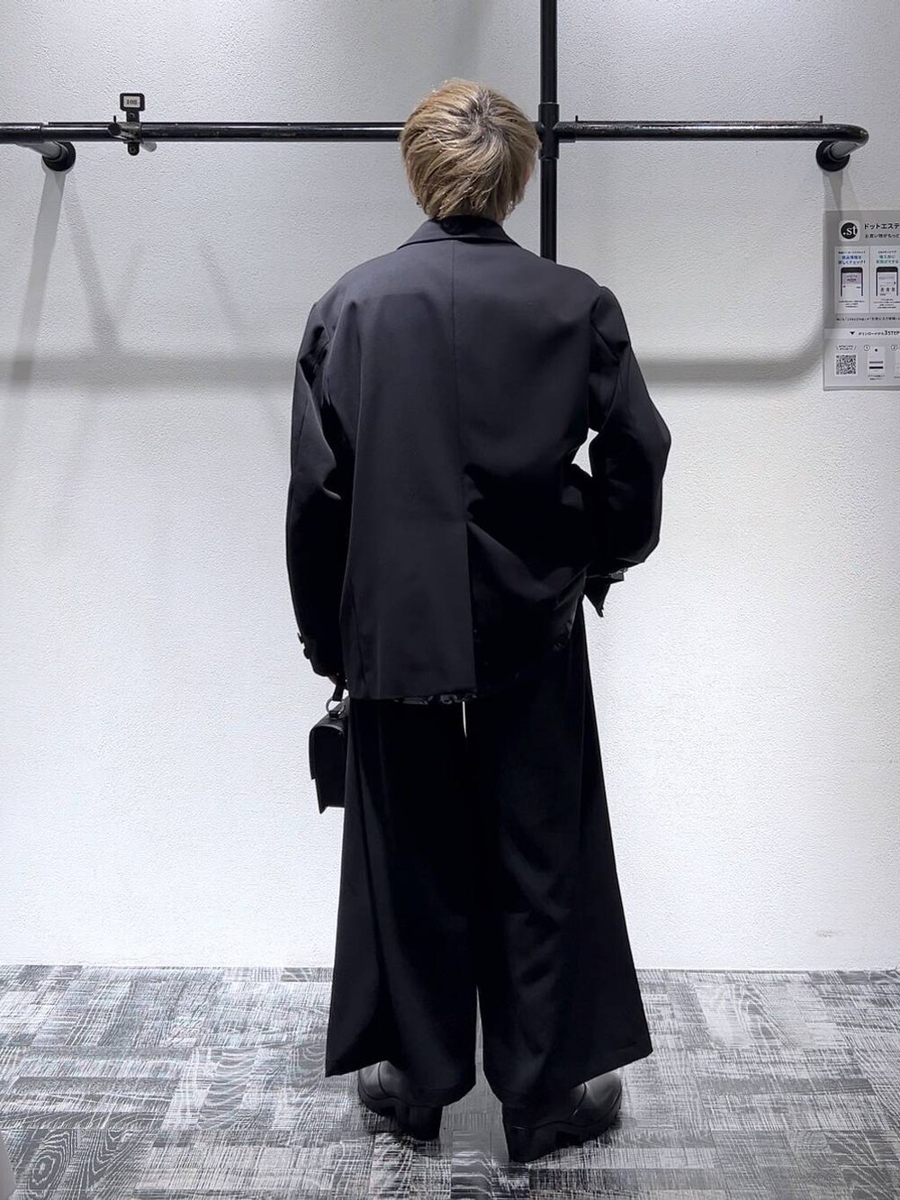 ブラック系のテーラードジャケット、ブラック系のショルダーバッグ、ブラック系のスラックスを着用したメンズの冬コーディネートの4枚目の写真