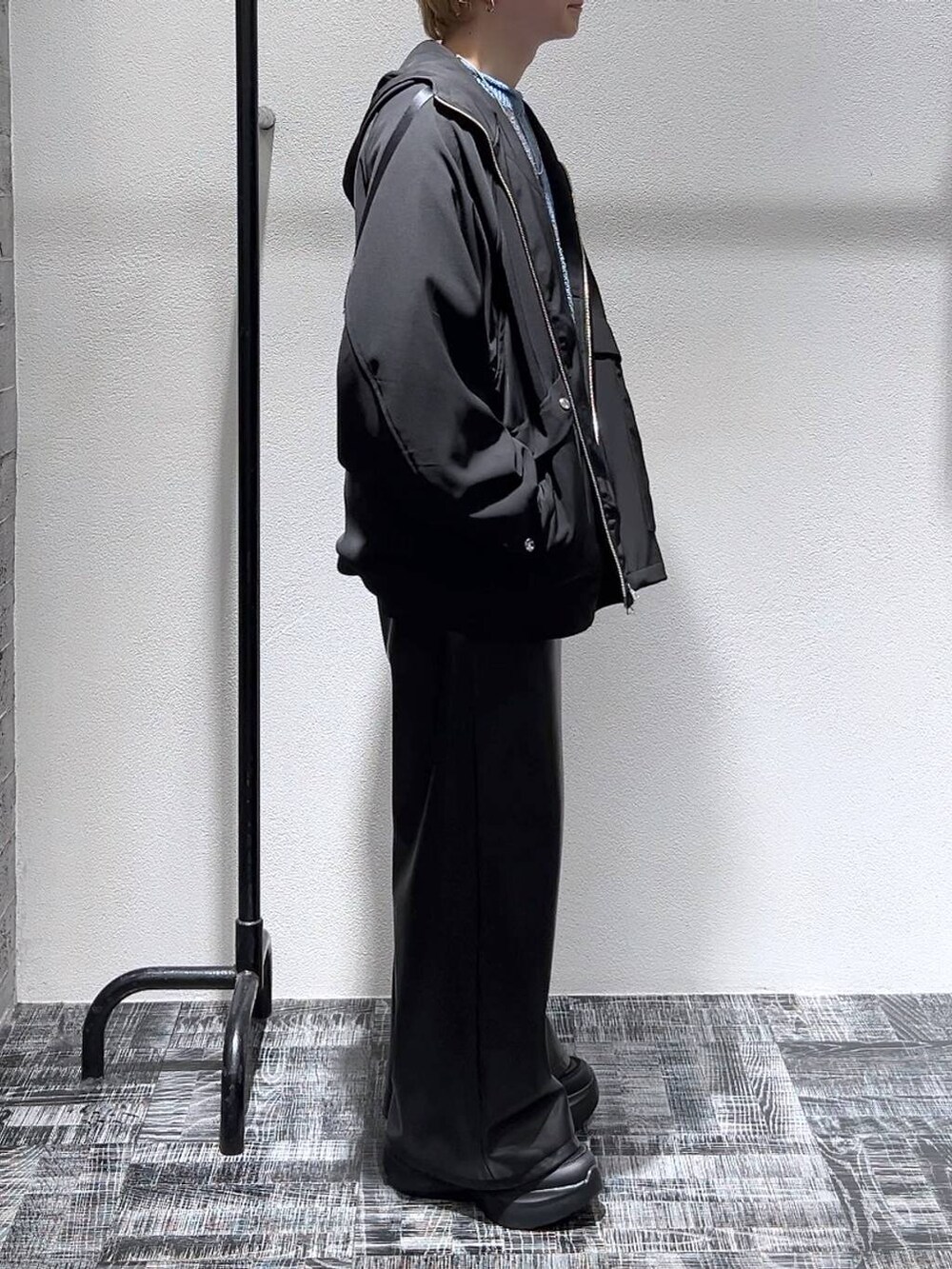ブルー系のニット/セーター、ブラック系のその他パンツ、ブラック系のスニーカーを着用したメンズの冬コーディネートの3枚目の写真