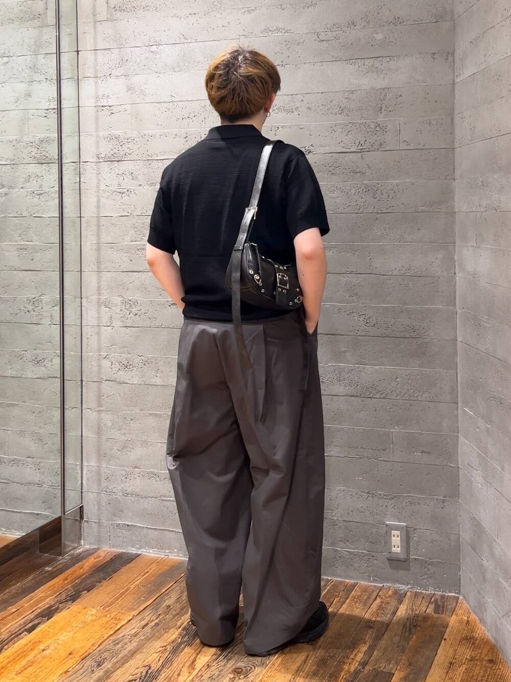 ブラック系のショルダーバッグ、ブラック系のローファー、グレー系のチノパンツを着用したメンズの夏コーディネートの3枚目の写真