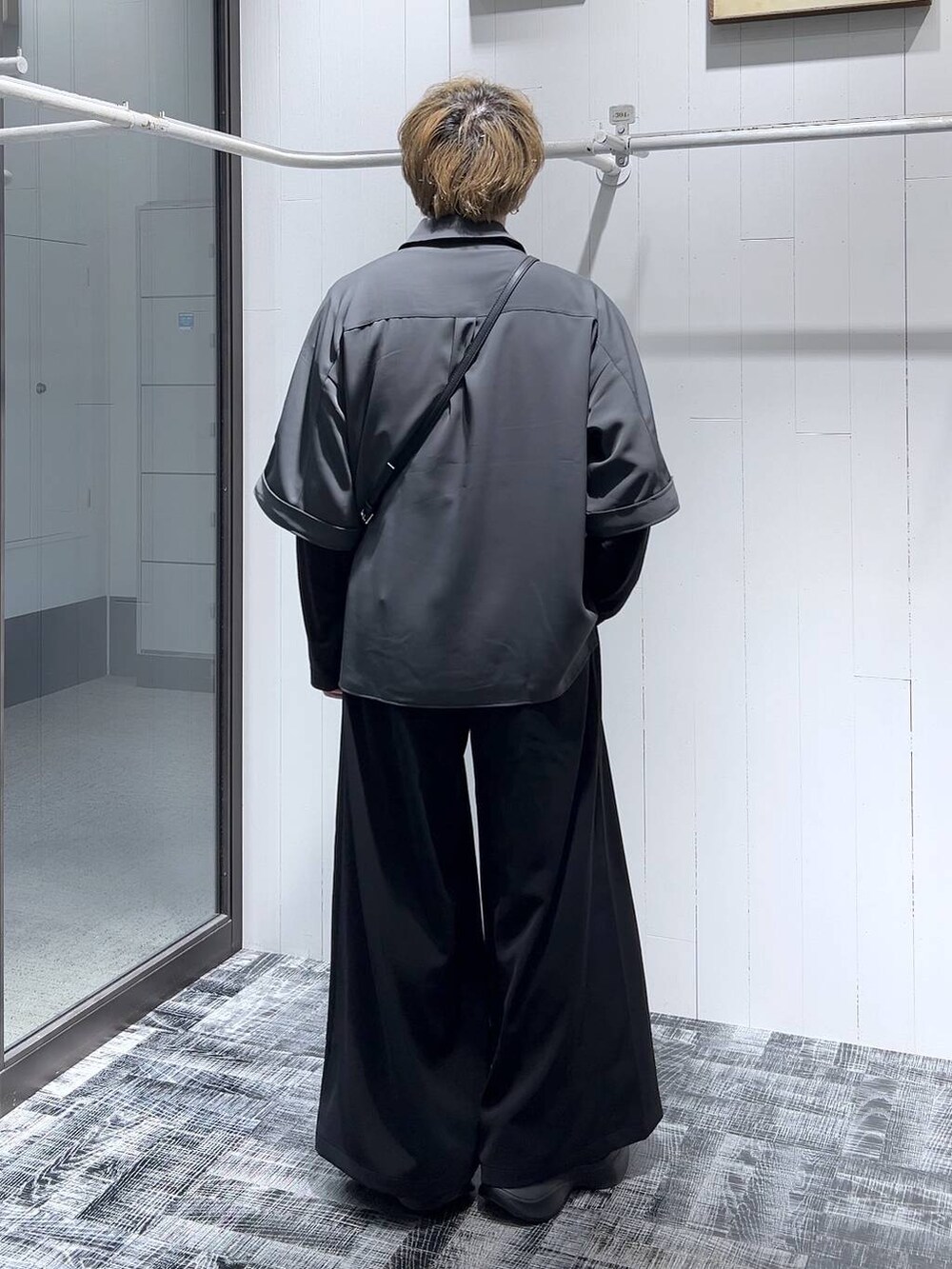 ブラック系のTシャツ/カットソー、ブラック系のショルダーバッグ、ブラック系のスラックスを着用したメンズの春コーディネートの4枚目の写真