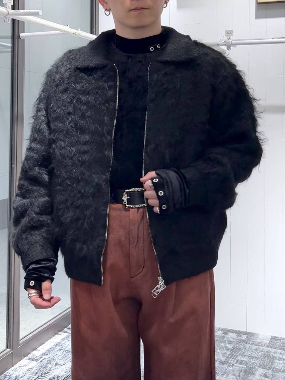 オレンジ系のデニムパンツ、ブラック系のTシャツ/カットソー、ブラック系のブーツを着用したメンズの冬コーディネートの5枚目の写真