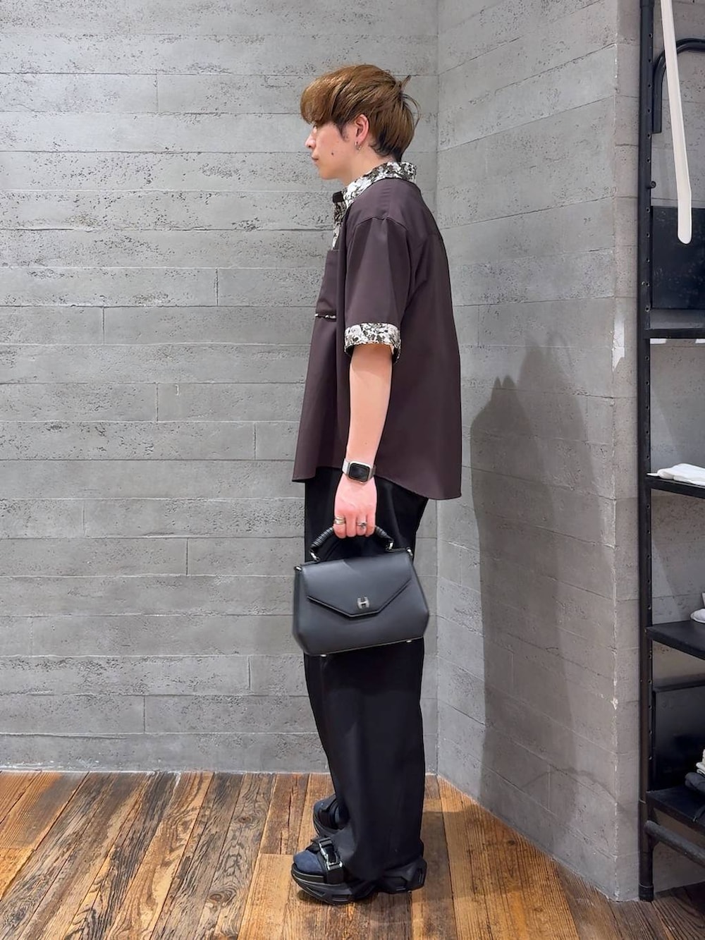 ブラック系のサンダル、ホワイト系のTシャツ/カットソー、ブラック系のスラックスを着用したメンズの春コーディネートの4枚目の写真