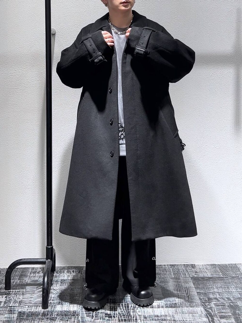 ブラック系のステンカラーコート、ブラック系のブーツ、グレー系のスウェットを着用したメンズの秋コーディネートの2枚目の写真