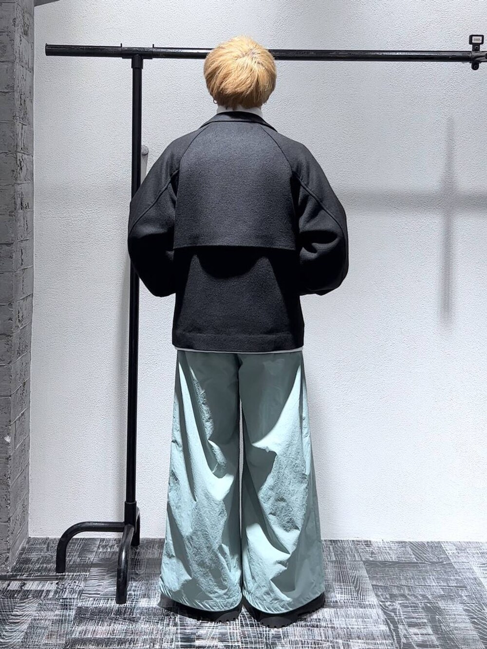 ブラック系のブルゾン、ブラック系のブーツ、ホワイト系のスウェットを着用したメンズの秋コーディネートの4枚目の写真