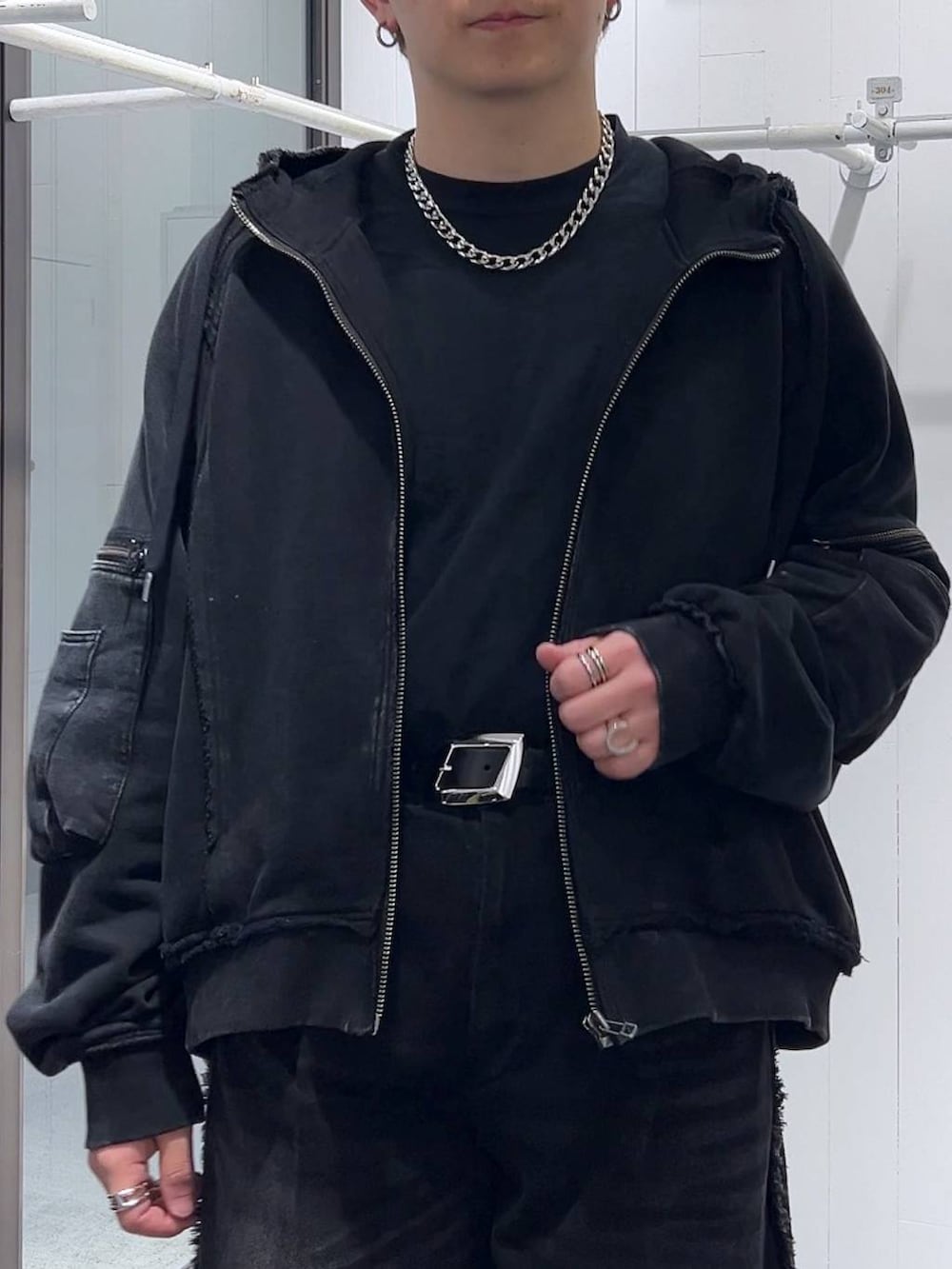 ブラック系のパーカー、ブラック系のブーツ、ブラック系のデニムパンツを着用したメンズの冬コーディネートの5枚目の写真