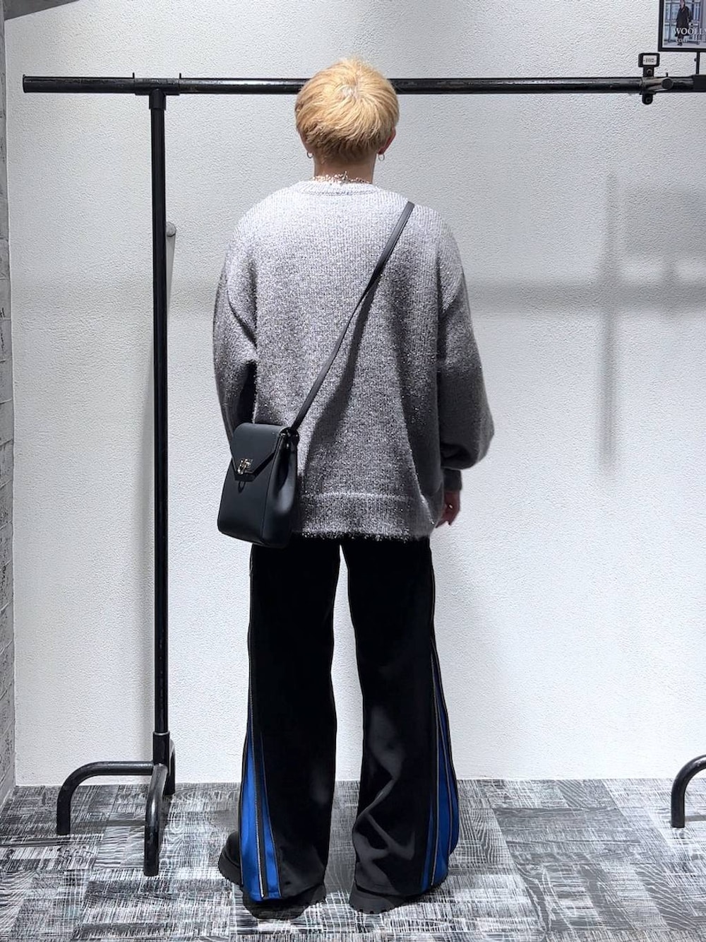 ブラック系のショルダーバッグ、ブラック系のブーツ、ブルー系のスラックスを着用したメンズの秋コーディネートの4枚目の写真