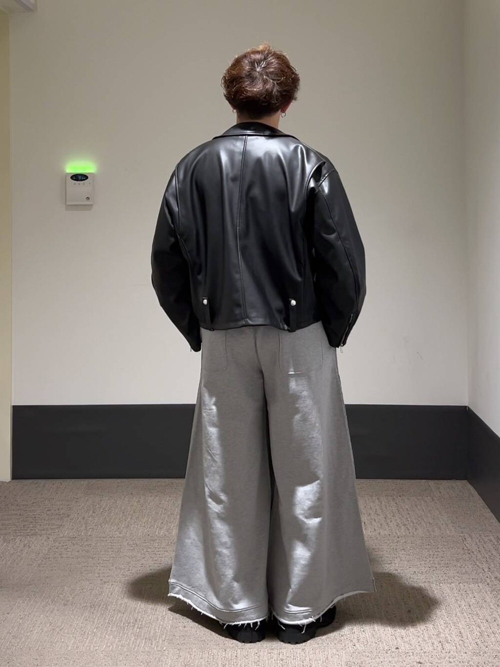 ブラック系のドレスシューズ、グレー系のスウェットパンツ、ブラック系のライダースジャケットを着用したメンズの秋コーディネートの3枚目の写真