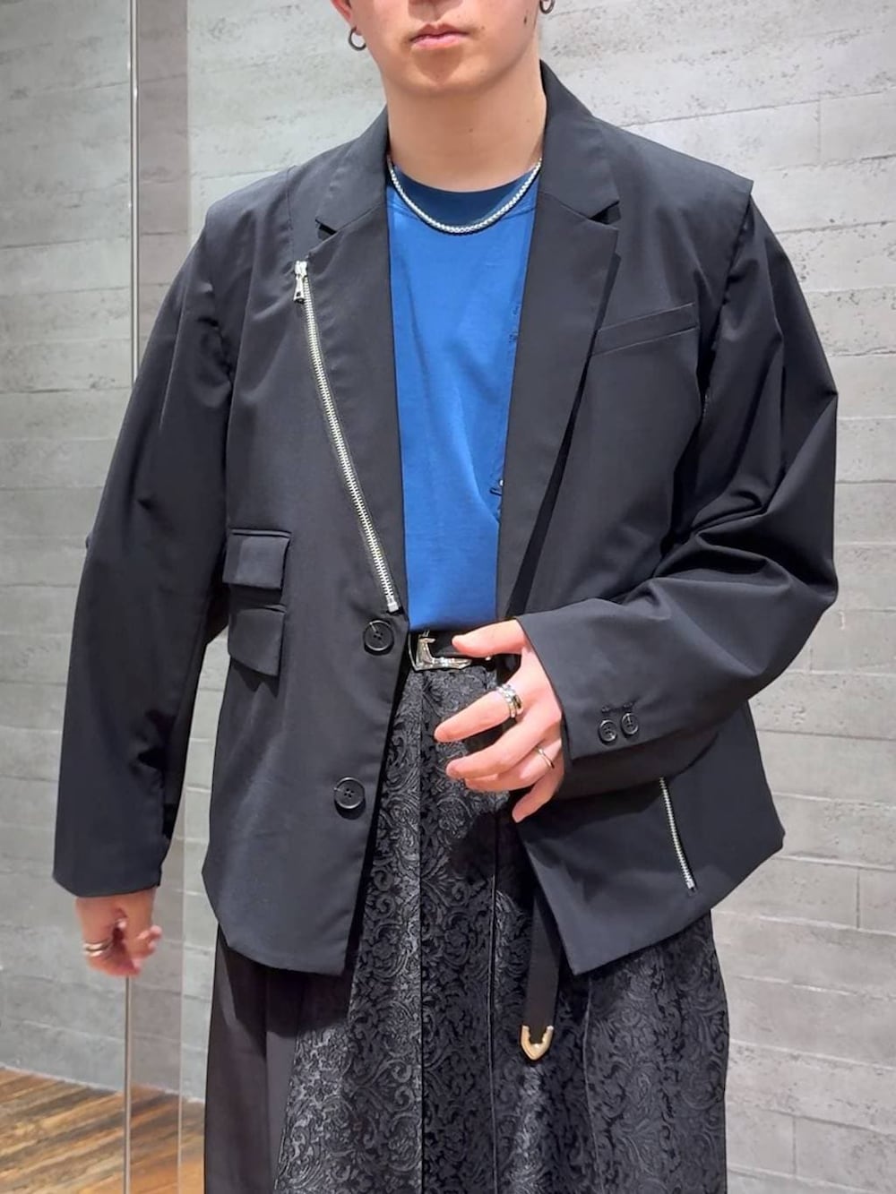 ブルー系のTシャツ/カットソー、ブラック系のサンダル、ブラック系のテーラードジャケットを着用したメンズの春コーディネートの5枚目の写真