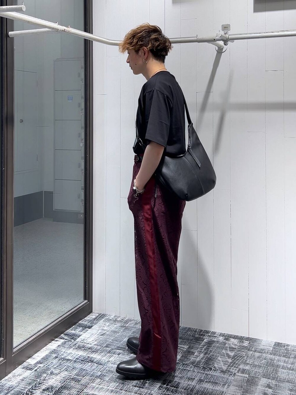 ブラック系のドレスシューズ、レッド系のその他パンツ、ブラック系のショルダーバッグを着用したメンズの夏コーディネートの2枚目の写真