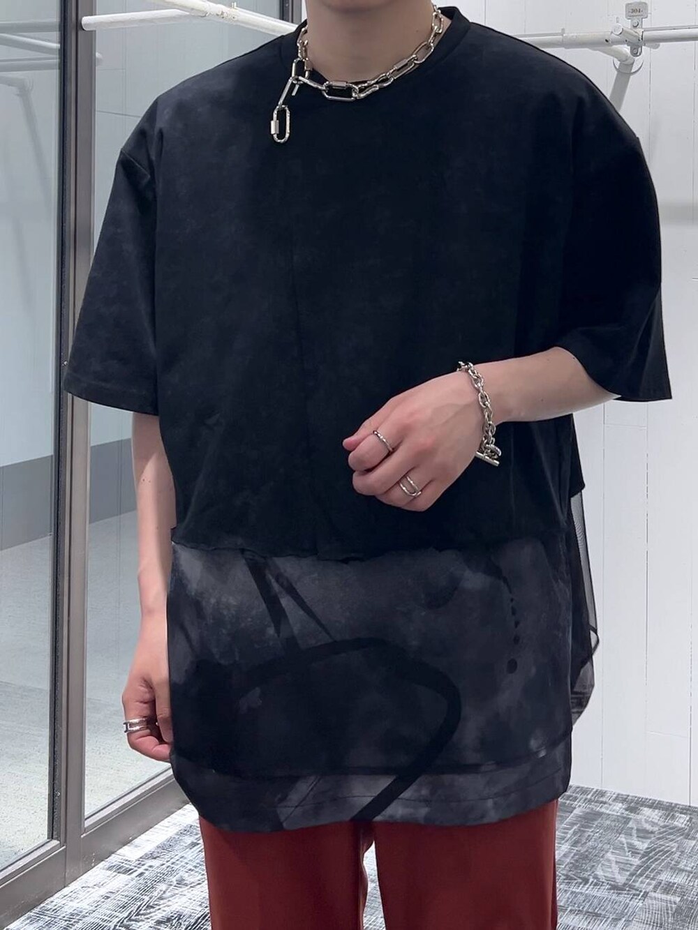 ブラック系のサンダル、オレンジ系のスラックス、ブラック系のTシャツ/カットソーを着用したメンズの夏コーディネートの4枚目の写真