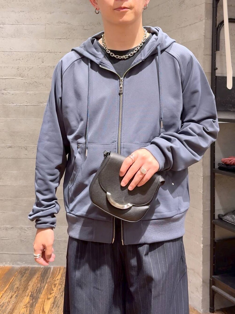 ブラック系のショルダーバッグ、ブルー系のスラックス、ブルー系のパーカーを着用したメンズの秋コーディネートの5枚目の写真