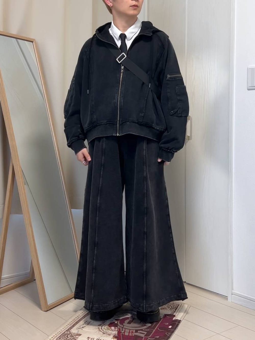 ブラック系のパーカー、グリーン系のニット/セーター、ブラック系のその他パンツを着用したメンズの冬コーディネートの4枚目の写真