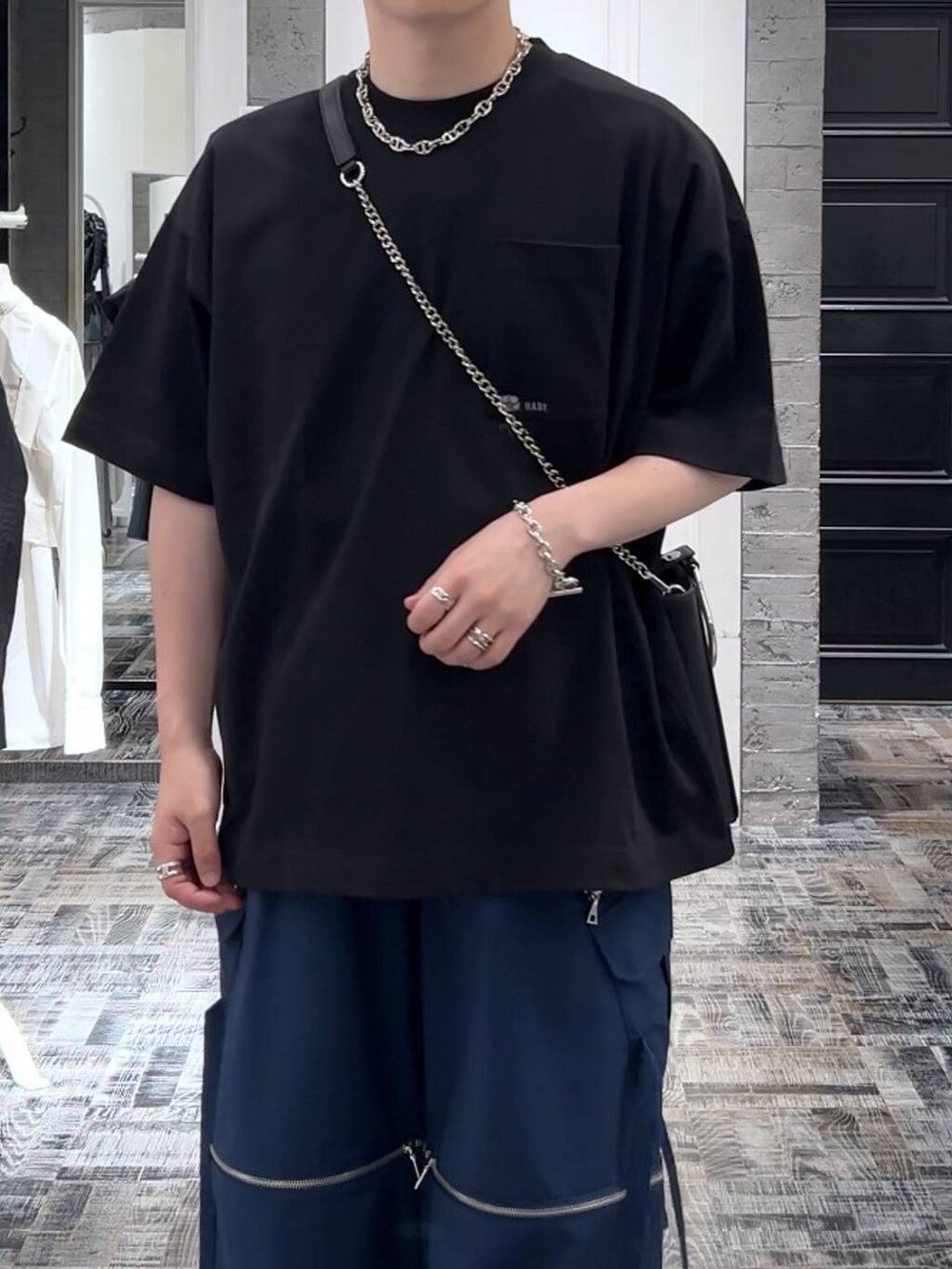 ブルー系のカーゴパンツ、ブラック系のドレスシューズ、ブラック系のTシャツ/カットソーを着用したメンズの夏コーディネートの5枚目の写真