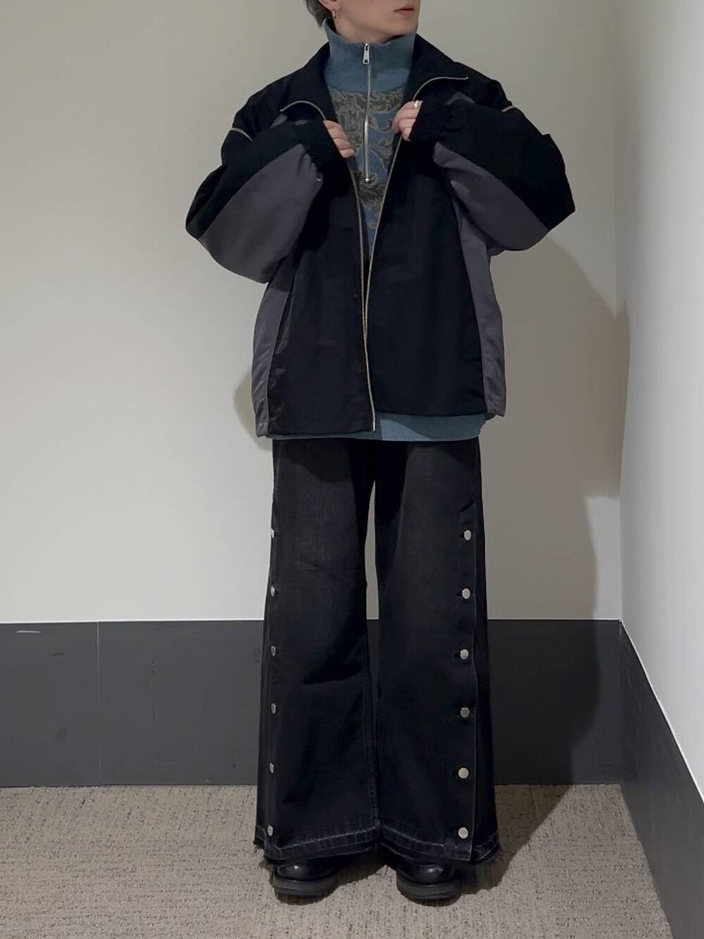 ブラック系のドレスシューズ、ブラック系のデニムパンツ、ブルー系のニット/セーターを着用したメンズの冬コーディネートの2枚目の写真