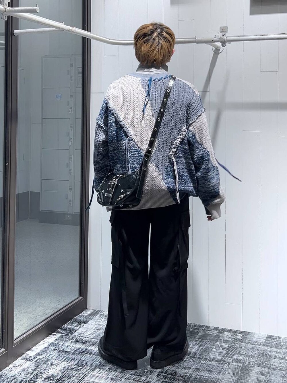 グレー系のカーディガン/ボレロ、グレー系のスウェット、ブラック系のカーゴパンツを着用したメンズの冬コーディネートの3枚目の写真