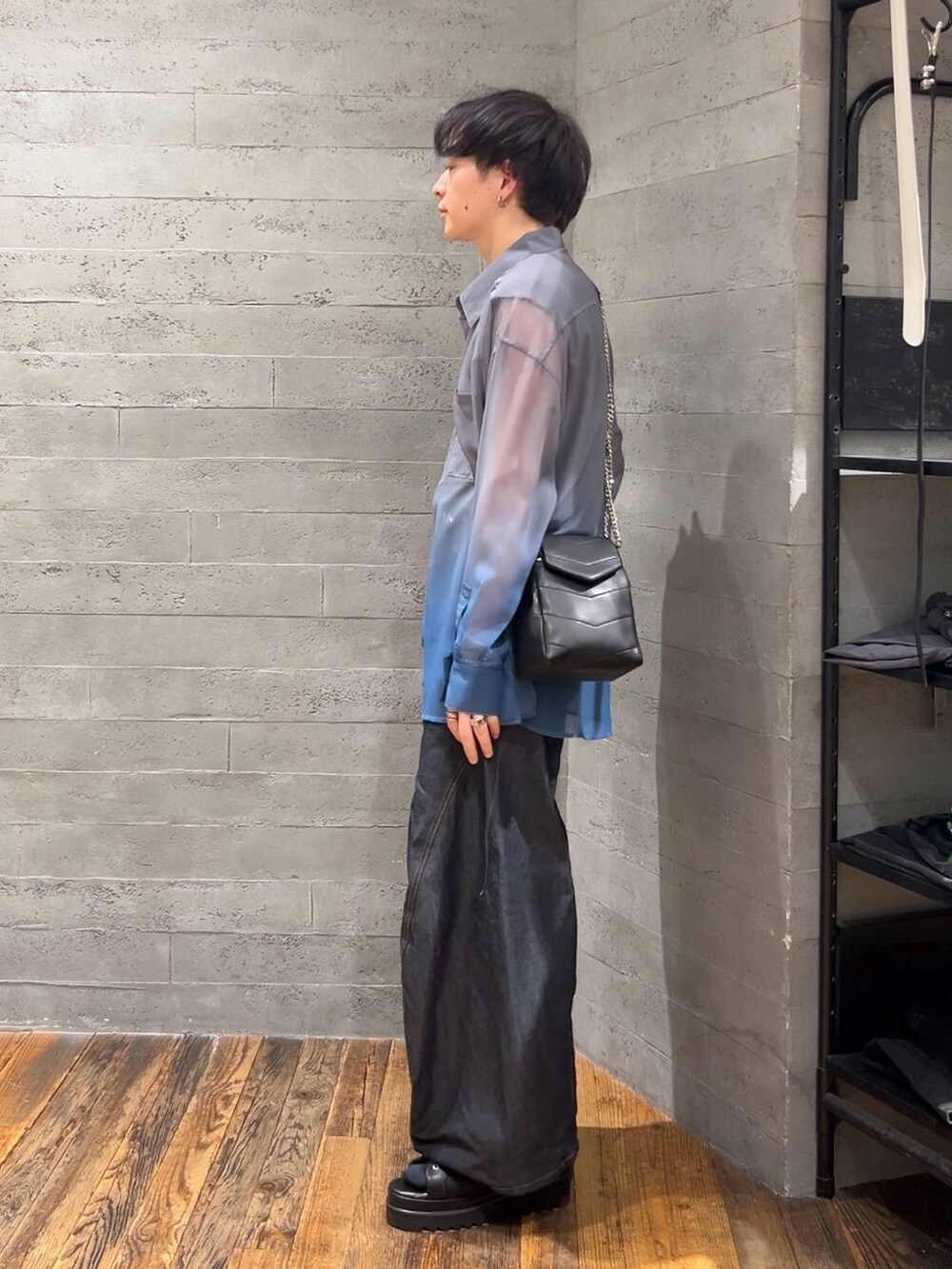 ブラック系のショルダーバッグ、ブルー系のデニムパンツ、ブラック系のサンダルを着用したメンズの春コーディネートの4枚目の写真