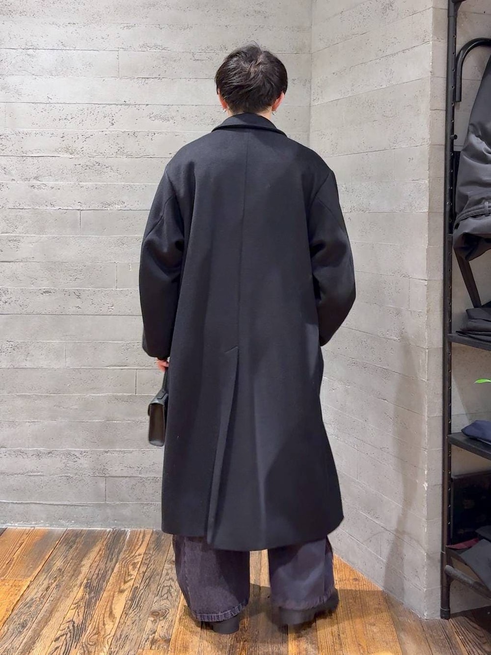 ブラック系のステンカラーコート、ブラック系のドレスシューズ、ブラック系のショルダーバッグを着用したメンズの冬コーディネートの3枚目の写真